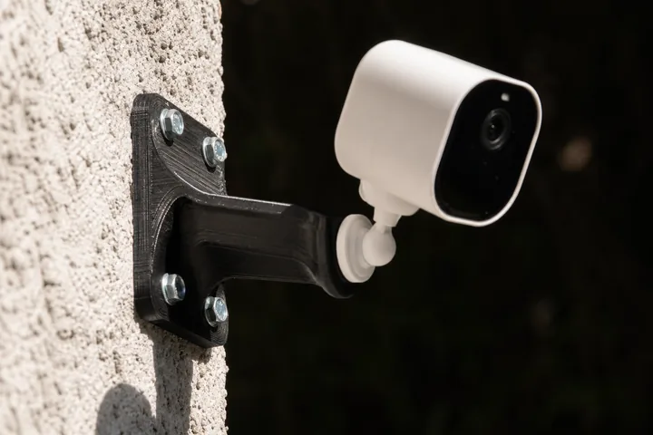 Soporte de pared impreso en PETG negro sujetando una cámara de seguridad a la intemperie